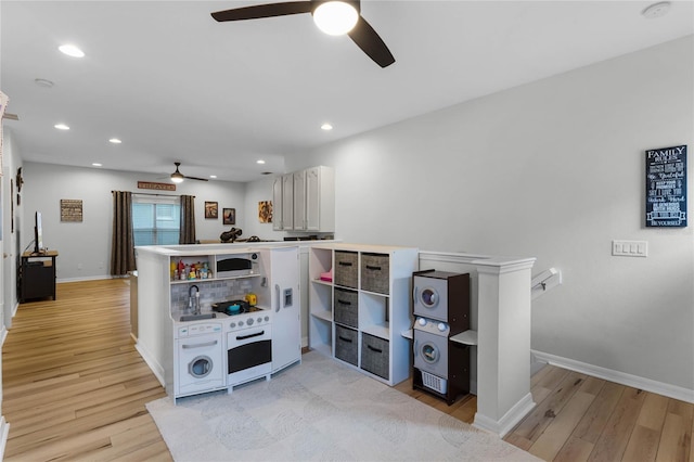 kitchen with kitchen peninsula, ceiling fan, and light wood-type flooring