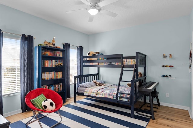 bedroom featuring ceiling fan, a textured ceiling, and light wood-type flooring