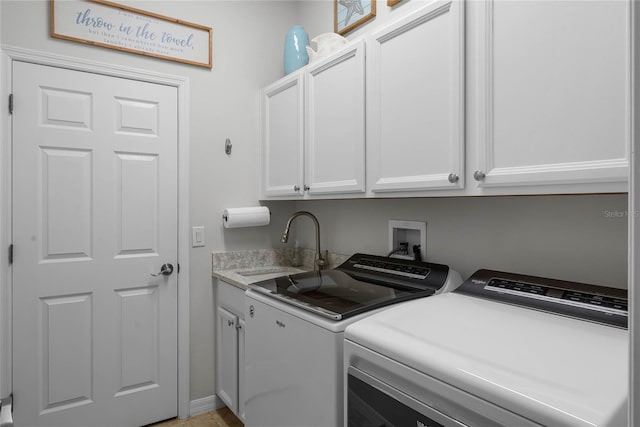 laundry area featuring cabinets, independent washer and dryer, and sink