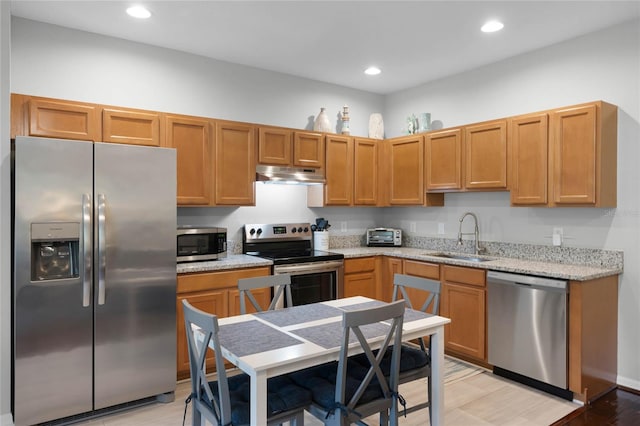 kitchen featuring light stone counters, appliances with stainless steel finishes, and sink