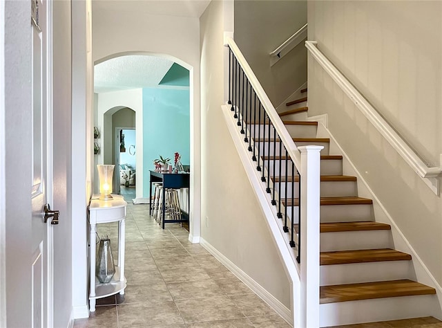 staircase featuring tile patterned flooring and a textured ceiling