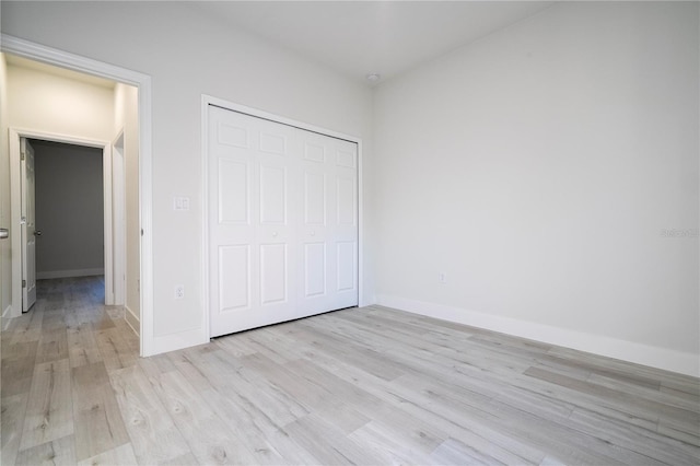 unfurnished bedroom featuring light hardwood / wood-style floors and a closet