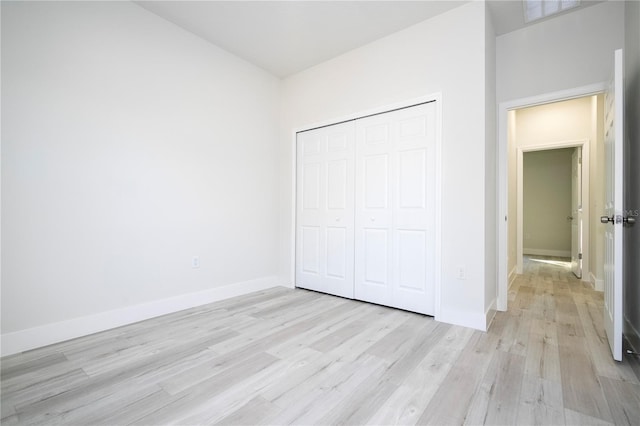 unfurnished bedroom with light hardwood / wood-style floors and a closet