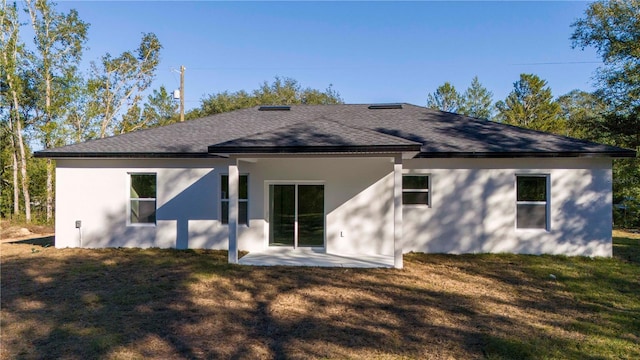 back of house featuring a lawn and a patio area