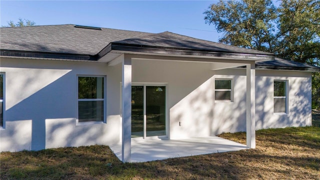 rear view of house featuring a lawn and a patio