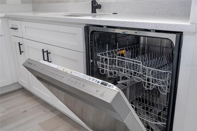 details with sink, white cabinets, and light wood-type flooring