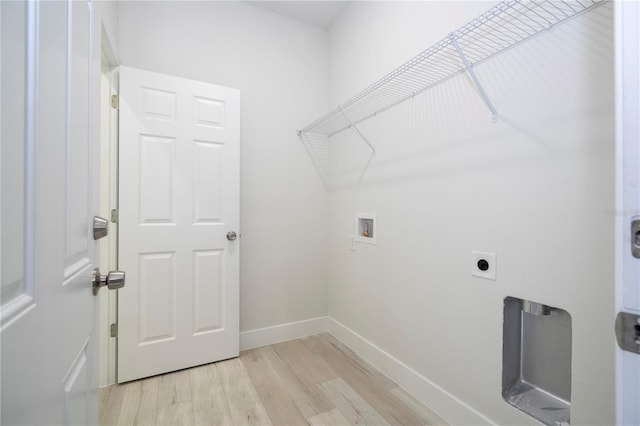 clothes washing area with electric dryer hookup, hookup for a washing machine, and light hardwood / wood-style floors