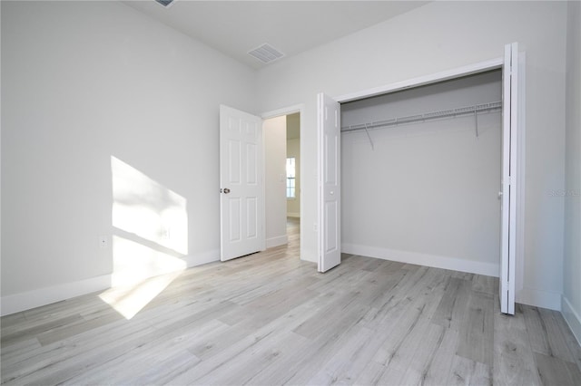 unfurnished bedroom featuring light hardwood / wood-style floors and a closet