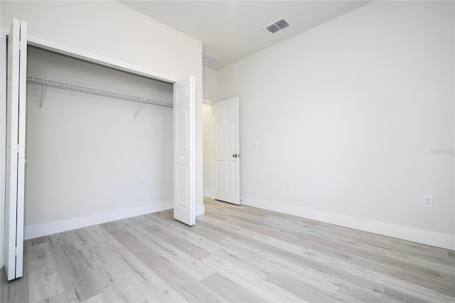 unfurnished bedroom with light hardwood / wood-style floors and a closet