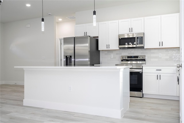 kitchen featuring white cabinetry, hanging light fixtures, a kitchen island, and appliances with stainless steel finishes