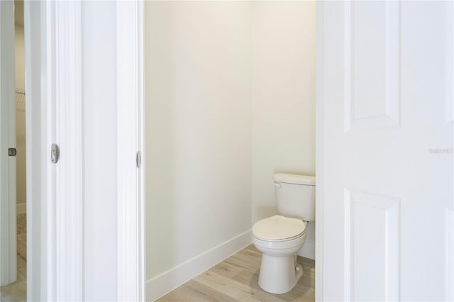 bathroom featuring hardwood / wood-style flooring and toilet