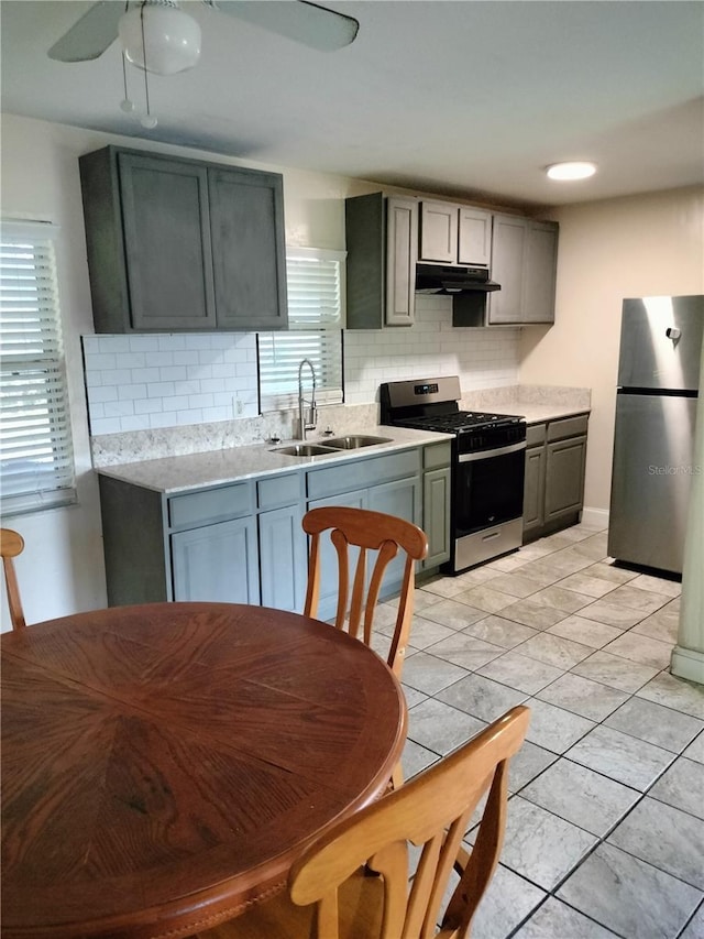 kitchen featuring stainless steel appliances, sink, decorative backsplash, and gray cabinetry