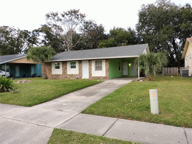 ranch-style house featuring cooling unit, a front lawn, and a carport