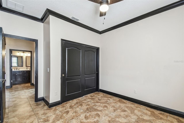 unfurnished bedroom with ornamental molding, sink, a textured ceiling, and ceiling fan