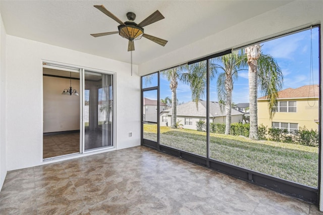 unfurnished sunroom featuring ceiling fan