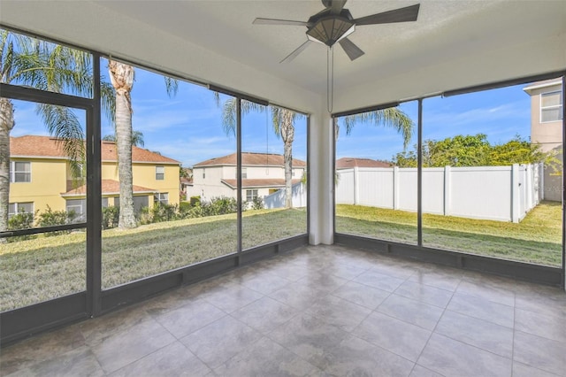 unfurnished sunroom with ceiling fan