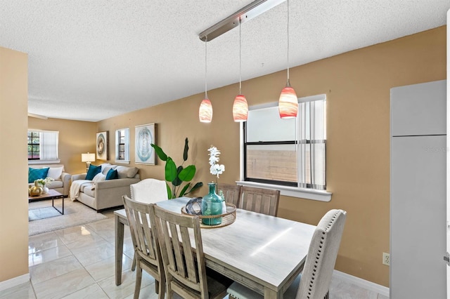 tiled dining area featuring a textured ceiling