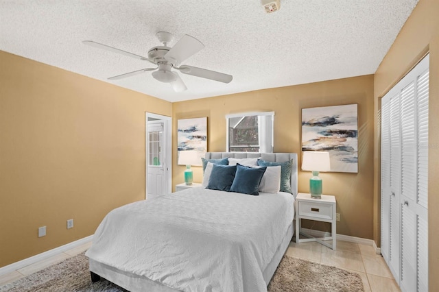 tiled bedroom featuring a textured ceiling, a closet, and ceiling fan