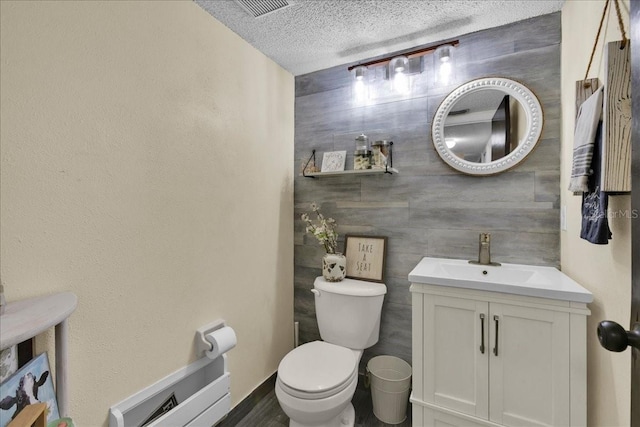 bathroom with vanity, toilet, and a textured ceiling