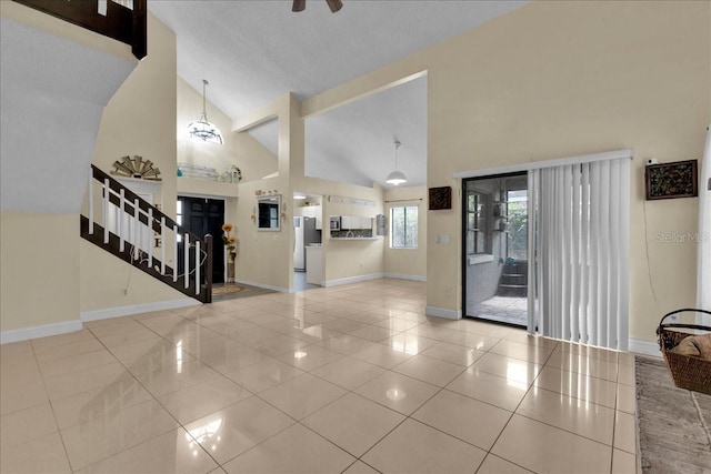 interior space featuring light tile patterned floors and high vaulted ceiling