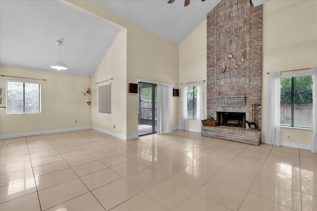 unfurnished living room with plenty of natural light, a fireplace, high vaulted ceiling, and light tile patterned floors