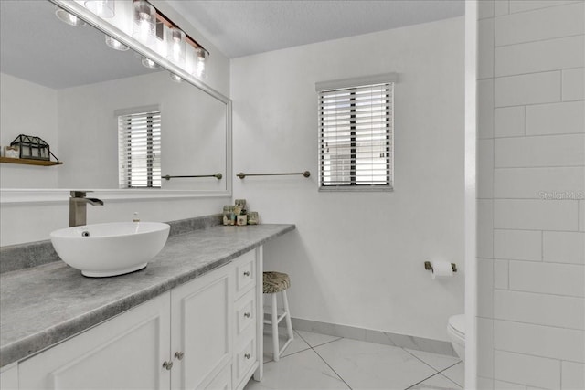 bathroom with vanity, a textured ceiling, and toilet