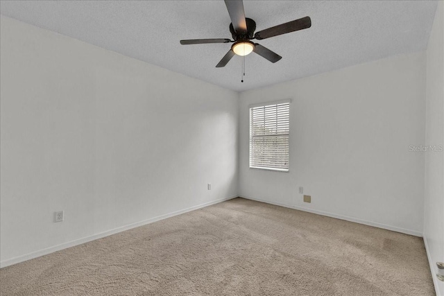 carpeted spare room featuring ceiling fan and a textured ceiling