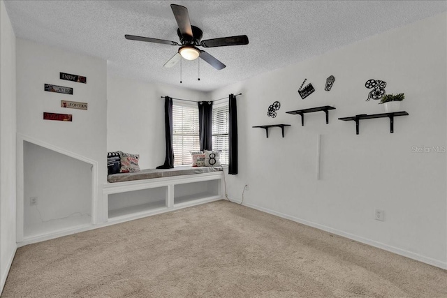 carpeted empty room with ceiling fan and a textured ceiling