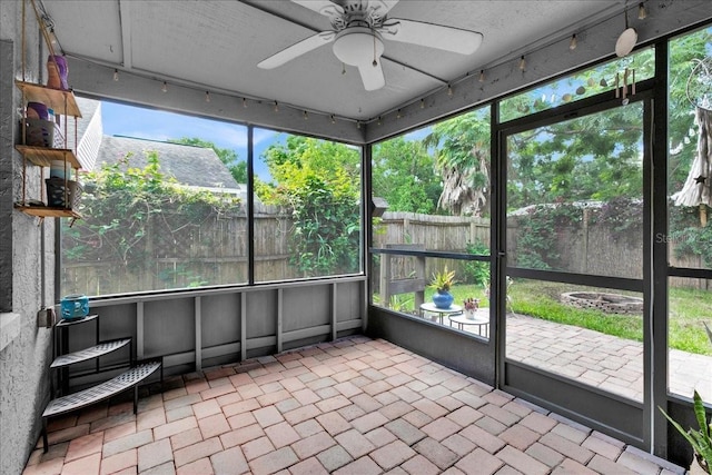 unfurnished sunroom with ceiling fan