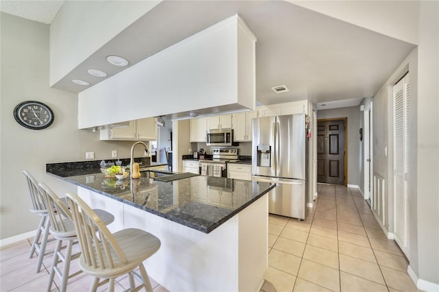 kitchen featuring stainless steel appliances, sink, a breakfast bar area, and kitchen peninsula