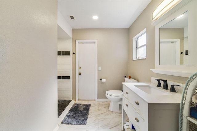 bathroom with a shower, vanity, and toilet