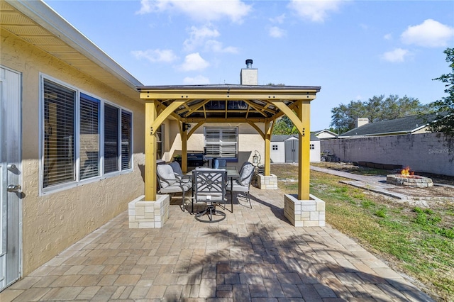 view of patio / terrace with a storage shed and a fire pit