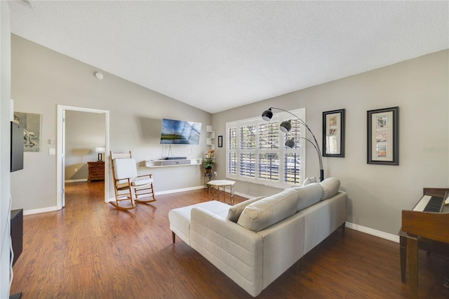 living room featuring dark wood-type flooring, lofted ceiling, and a textured ceiling