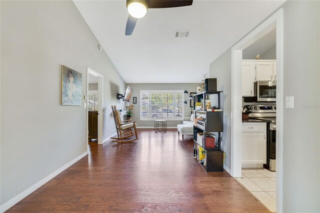 2537 Lanier Rd, Kissimmee, FL 34744 - living area featuring wood finished floors, a ceiling fan, lofted ceiling, and baseboards