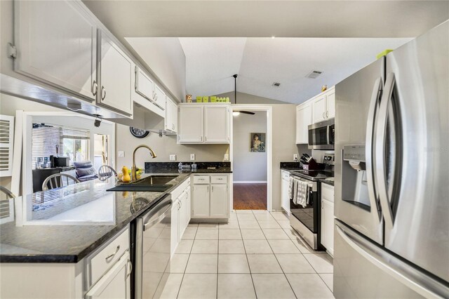 2537 Lanier Rd, Kissimmee, FL 34744 - kitchen with appliances with stainless steel finishes, a sink, lofted ceiling, light tile patterned floors, and white cabinets