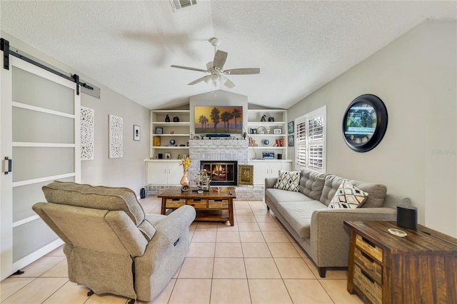 2537 Lanier Rd, Kissimmee, FL 34744 - living room featuring vaulted ceiling, a barn door, light tile patterned floors, ceiling fan, and built in features