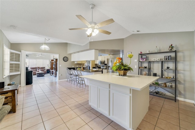 2537 Lanier Rd, Kissimmee, FL 34744 - kitchen featuring a ceiling fan, vaulted ceiling, appliances with stainless steel finishes, white cabinets, and light tile patterned floors