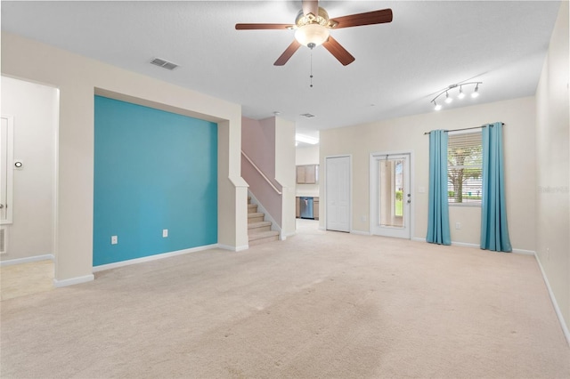 unfurnished living room with visible vents, stairway, light carpet, ceiling fan, and baseboards