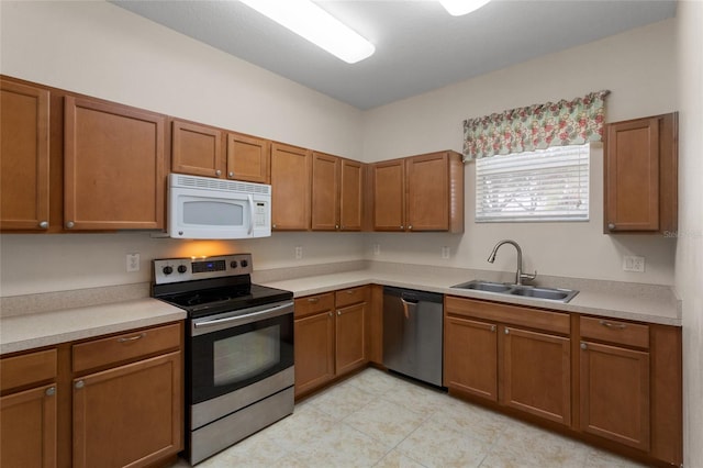 kitchen featuring a sink, brown cabinets, stainless steel appliances, and light countertops