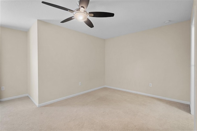 unfurnished room with light carpet, a ceiling fan, and baseboards