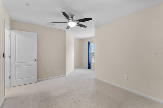 empty room with light carpet, ceiling fan, visible vents, and baseboards