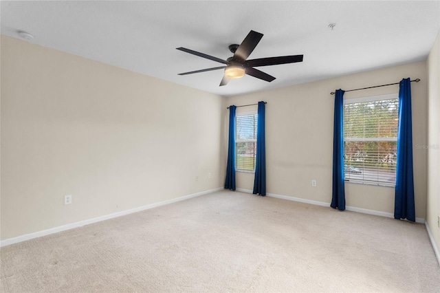 spare room with light carpet, plenty of natural light, and baseboards