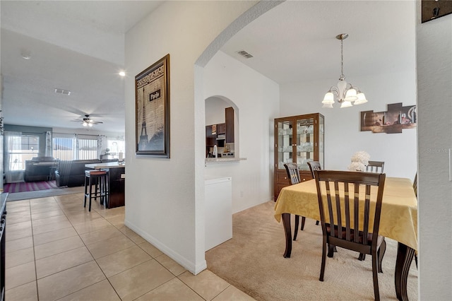 dining area with ceiling fan with notable chandelier and light tile patterned floors