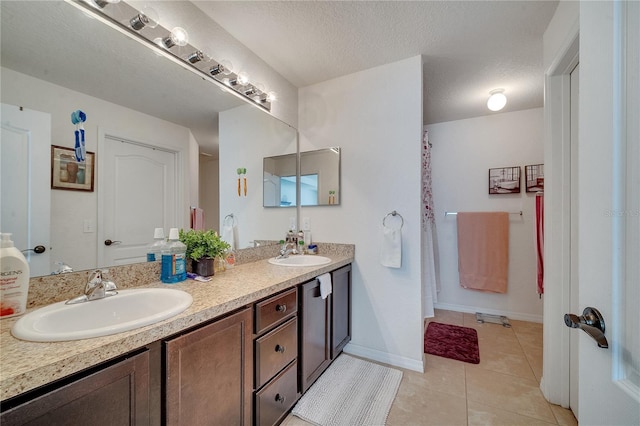 bathroom featuring vanity, tile patterned flooring, and a textured ceiling