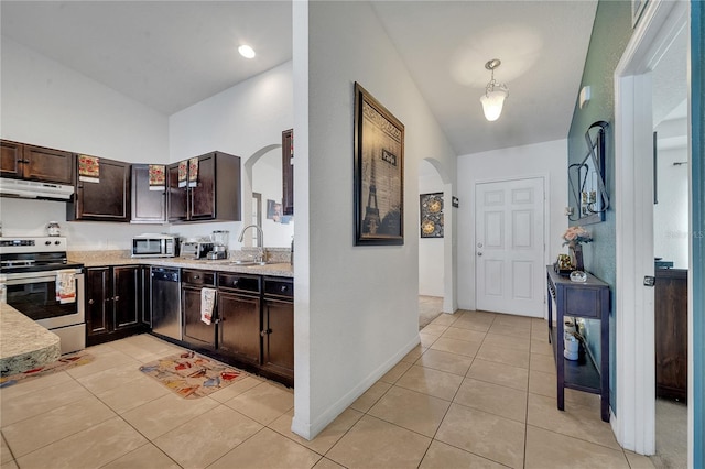 kitchen featuring dark brown cabinets, stainless steel appliances, vaulted ceiling, light tile patterned floors, and sink