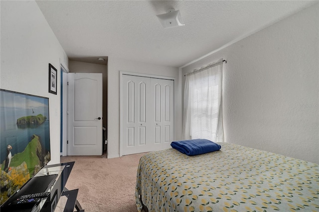 carpeted bedroom with a textured ceiling and a closet