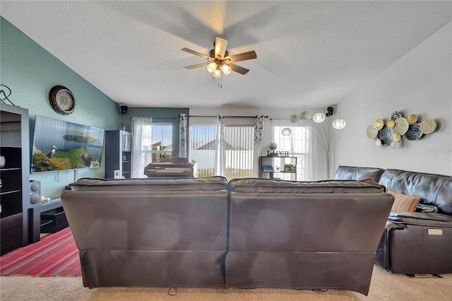 carpeted living room featuring ceiling fan, a textured ceiling, and lofted ceiling