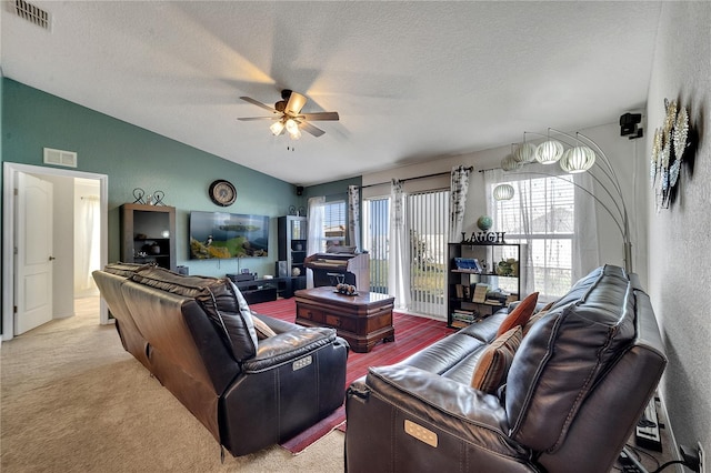 carpeted living room featuring a textured ceiling, lofted ceiling, and ceiling fan