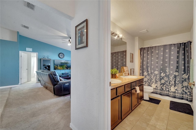 bathroom featuring lofted ceiling, vanity, a textured ceiling, ceiling fan, and toilet