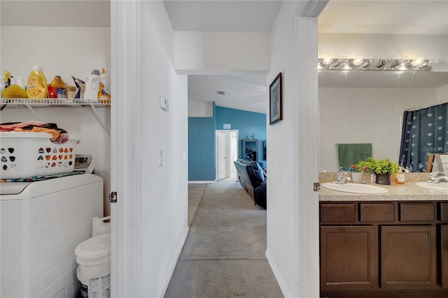 bathroom featuring vaulted ceiling, washer / clothes dryer, and vanity